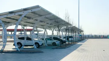 Solar carport canopy structure covering commercial parking lot with panels overhead