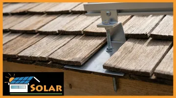 Solar panel flashing and mounting hardware installed on wood shake roof surface