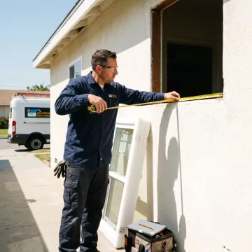 Installer measuring a replacement window opening