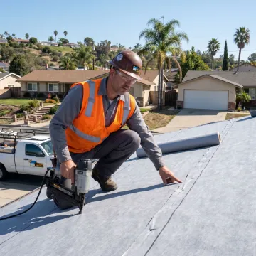 Roofing contractor inspecting a replacement roof