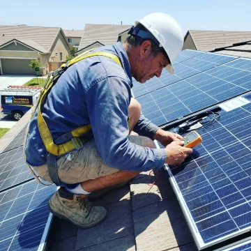 Solar installer reviewing rooftop panels