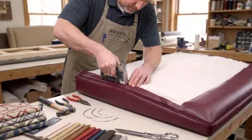 CallNeuco craftsman reupholstering commercial furniture with fabric swatches nearby