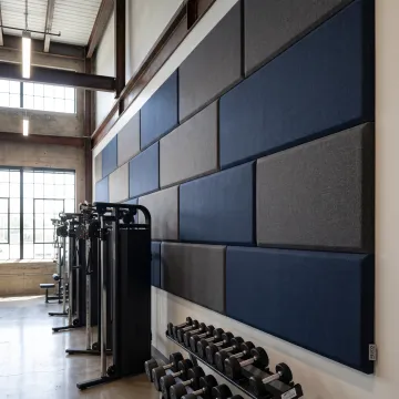 Fabric-wrapped acoustic panels installed in a modern gym