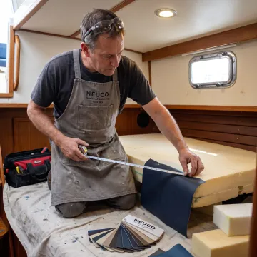 Upholstery professional measuring a boat seat cushion