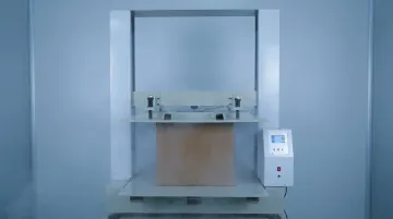 Corrugated cardboard box compression strength testing in industrial laboratory setting