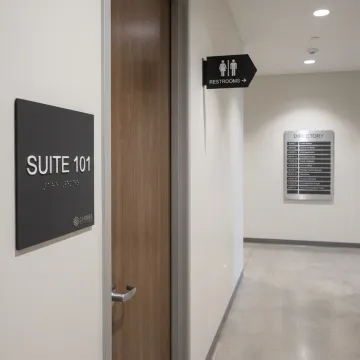 Custom ADA and wayfinding signs in an office hallway