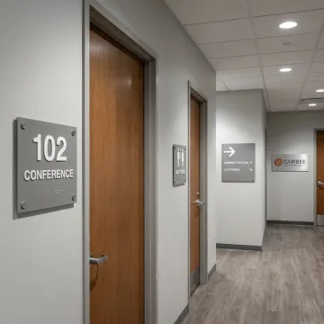 ADA and wayfinding signs in a commercial hallway