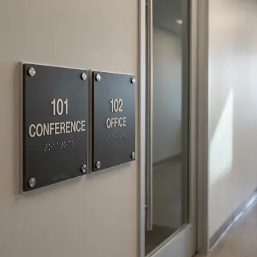 Tactile ADA signs in modern hallway