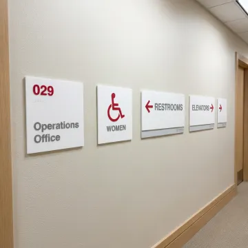 ADA and wayfinding signs in commercial hallway