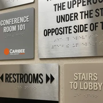 ADA Braille and wayfinding signs in a commercial hallway