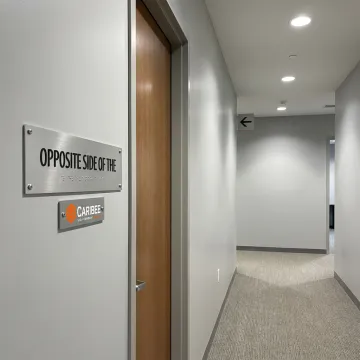 ADA and wayfinding signs in a commercial building hallway