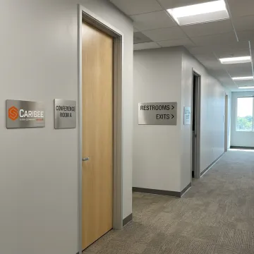 Custom ADA and wayfinding signs in a modern commercial hallway