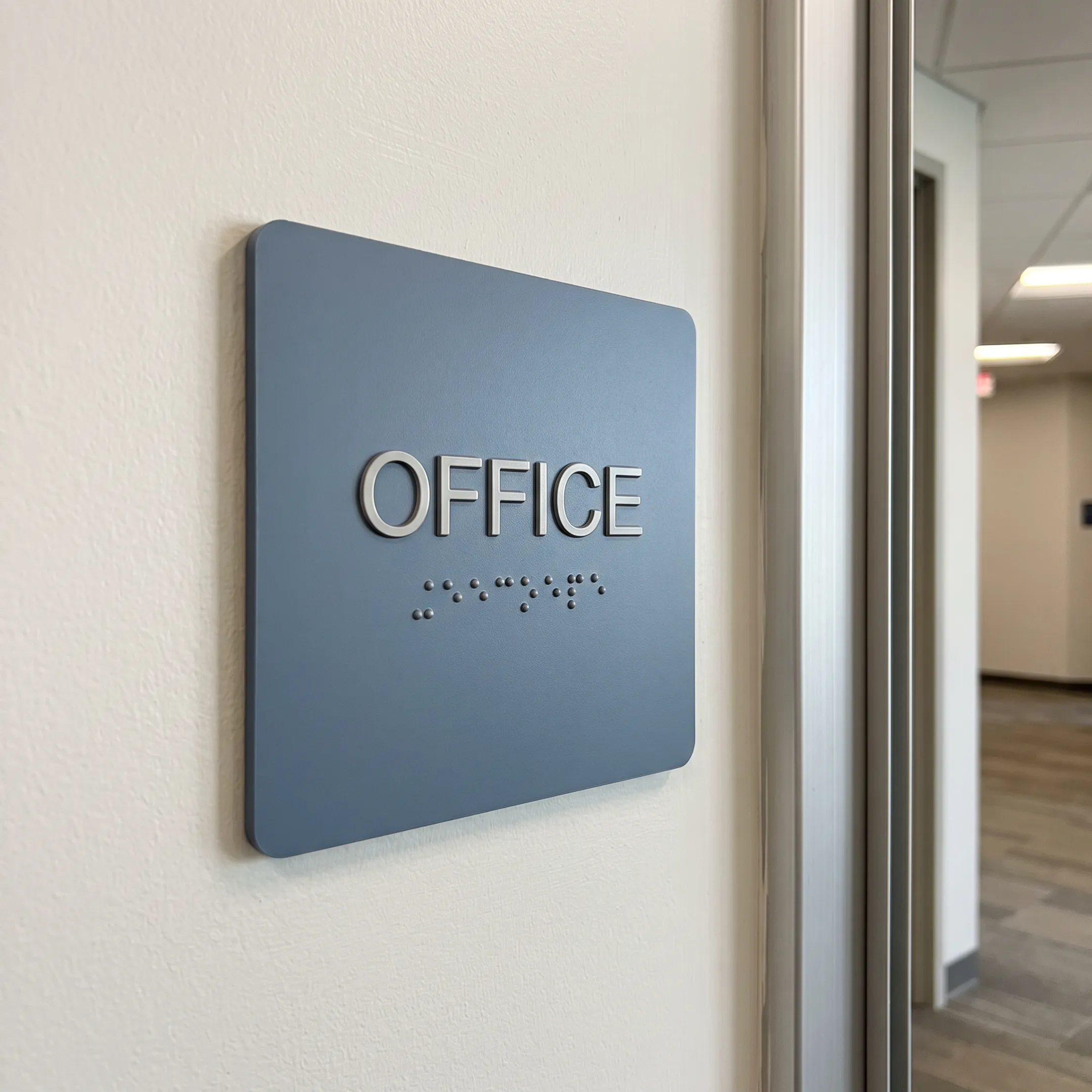 ADA tactile and Braille sign mounted beside a doorway