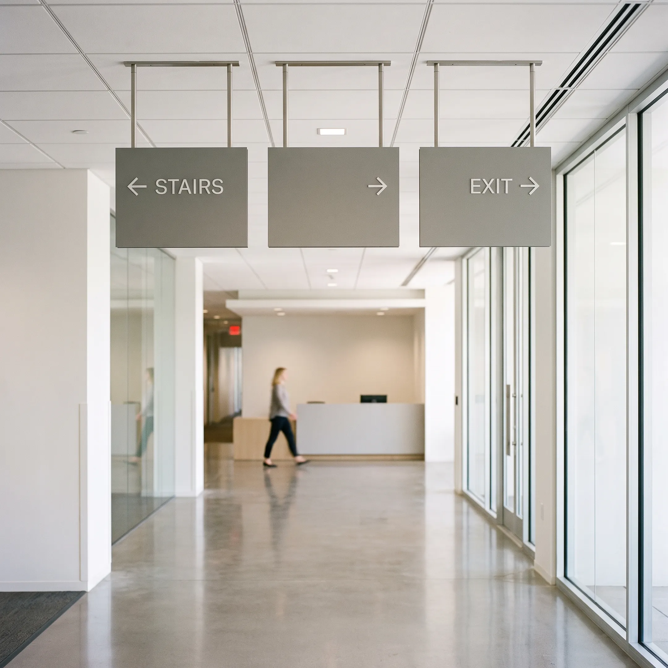 Suspended directional wayfinding signs in a commercial interior