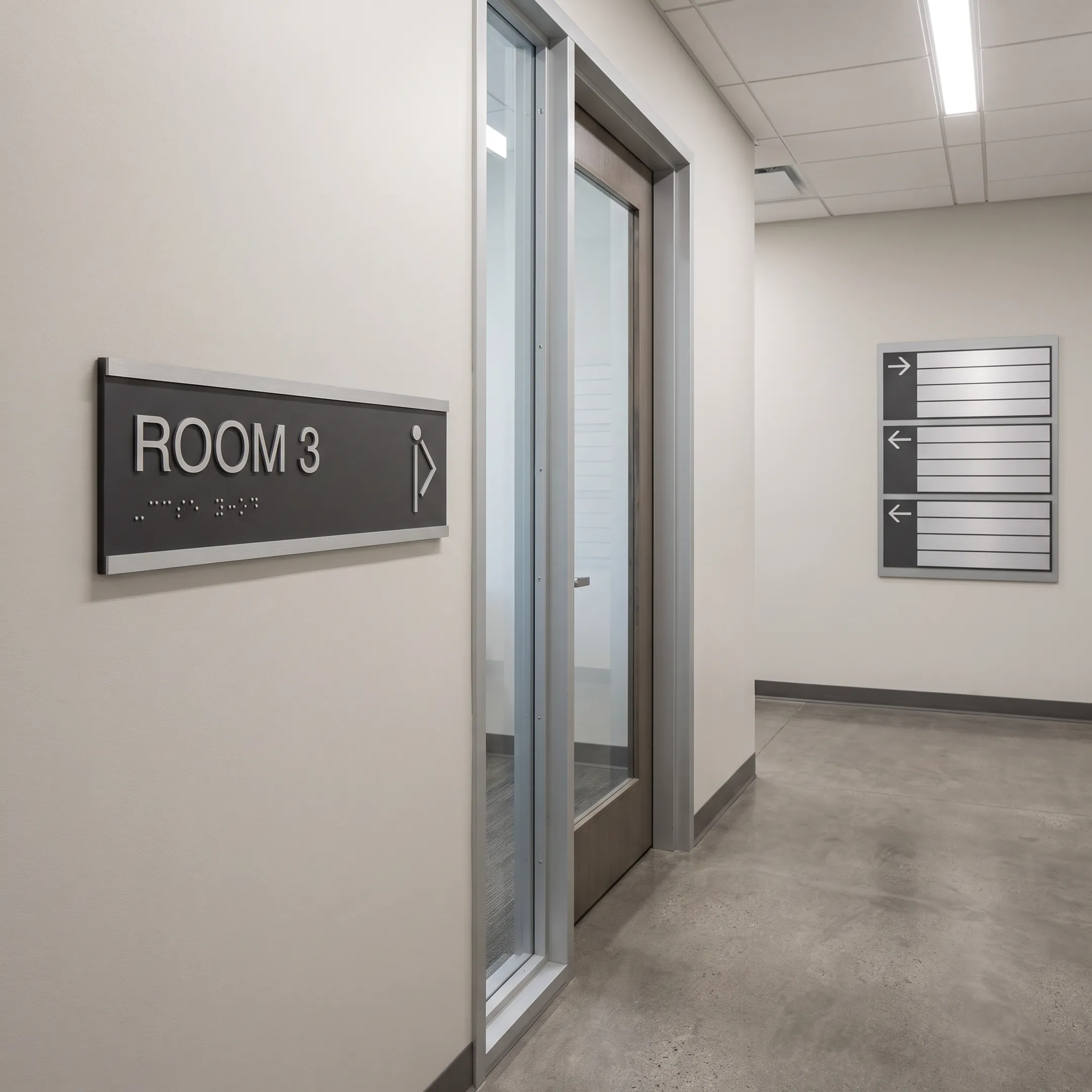 ADA and wayfinding signs in commercial hallway