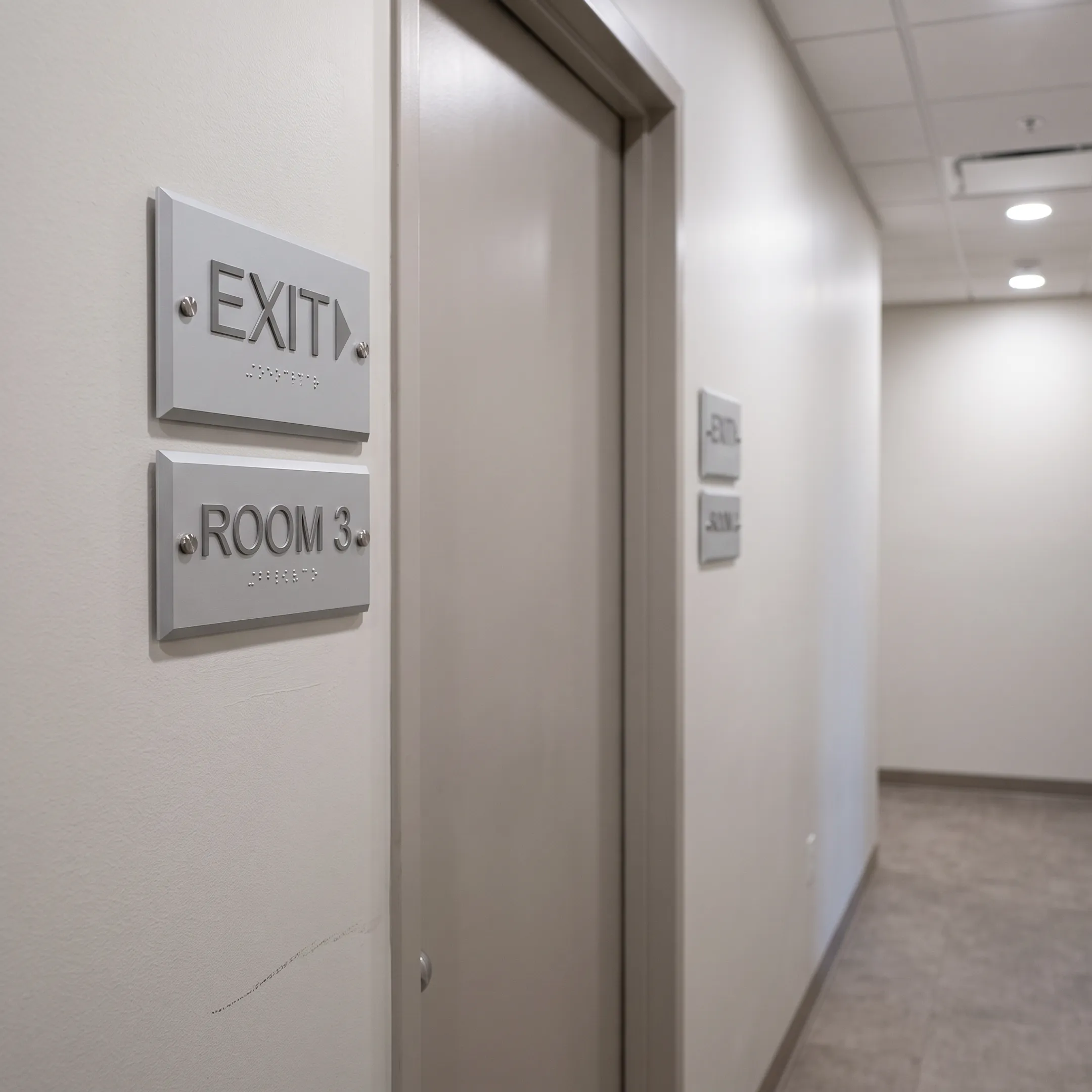Custom ADA and wayfinding signs in an office hallway
