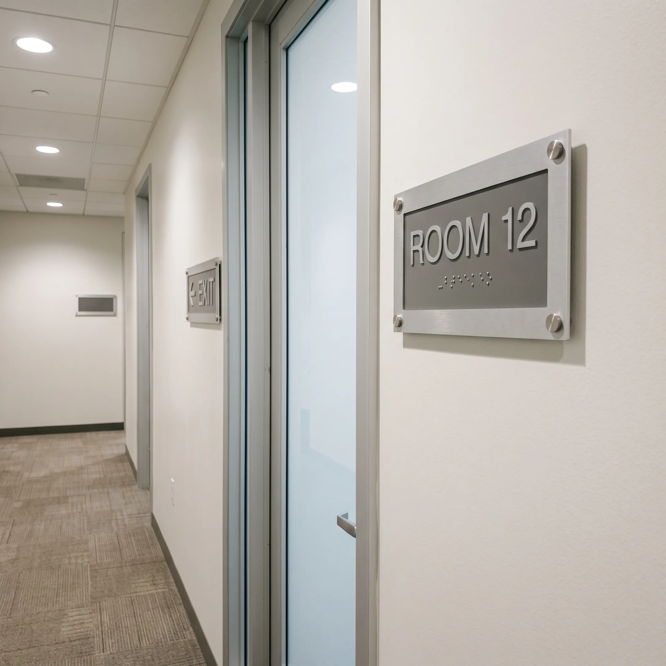ADA and wayfinding signs in a commercial building hallway