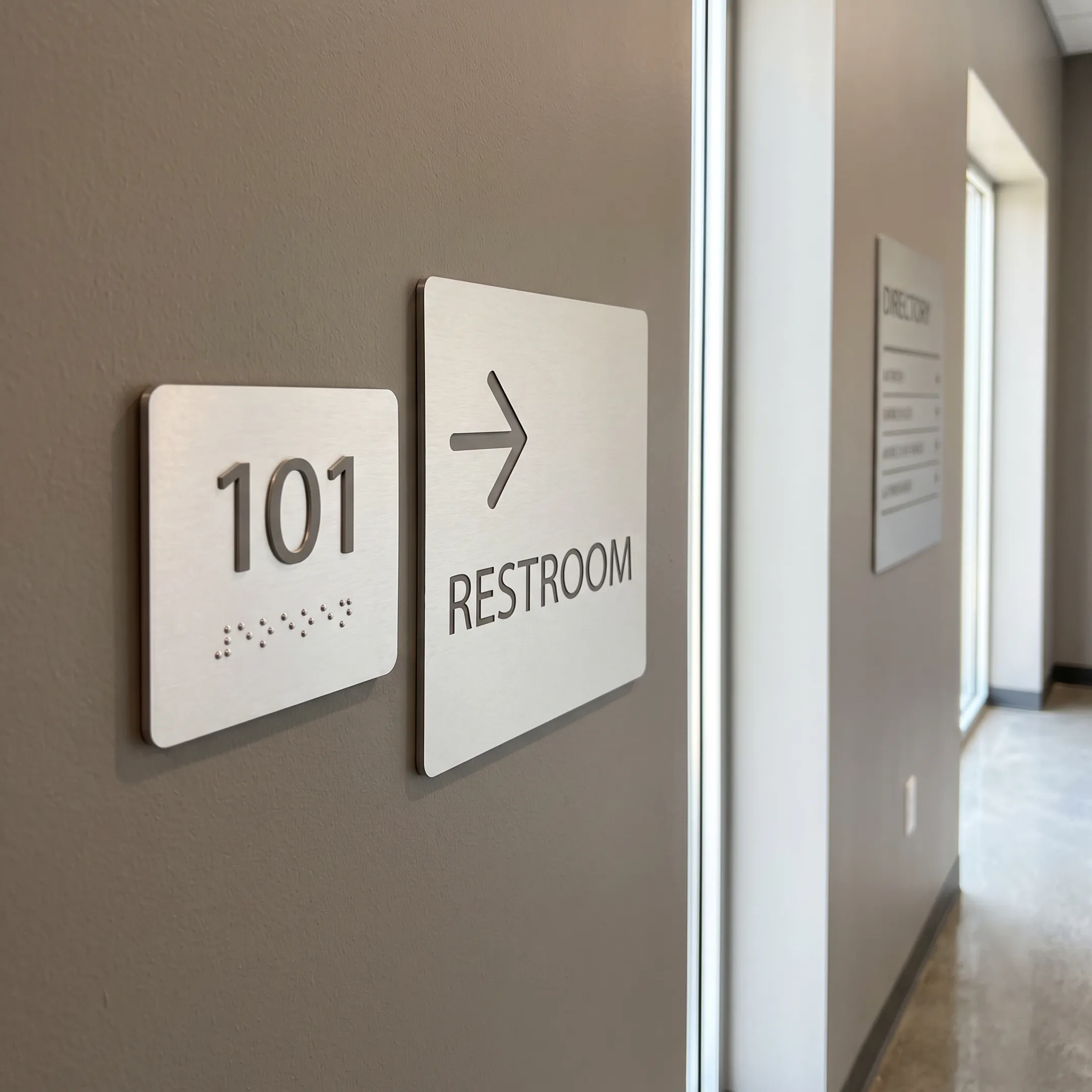 ADA and wayfinding signs in a commercial hallway