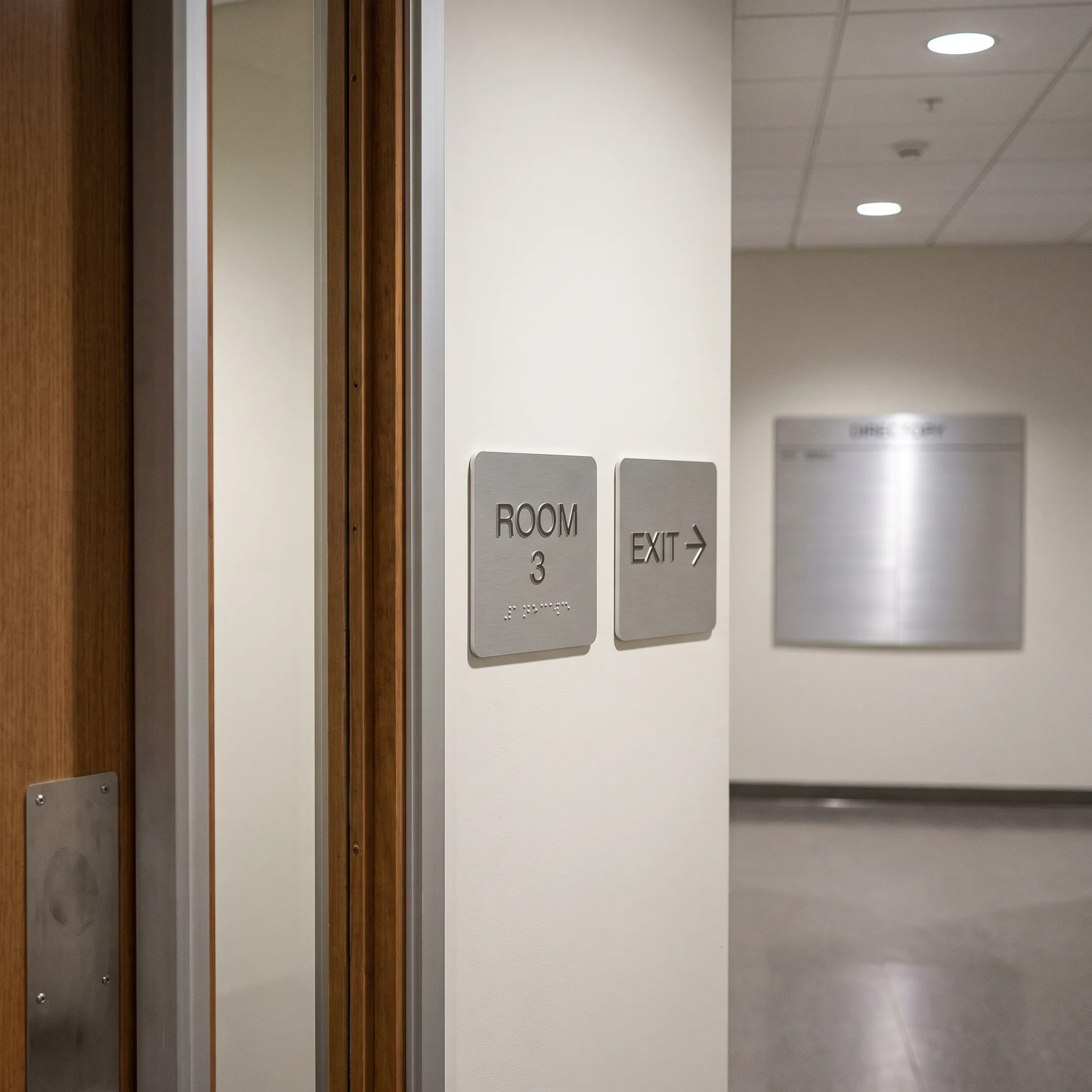 ADA and wayfinding signs in a commercial hallway