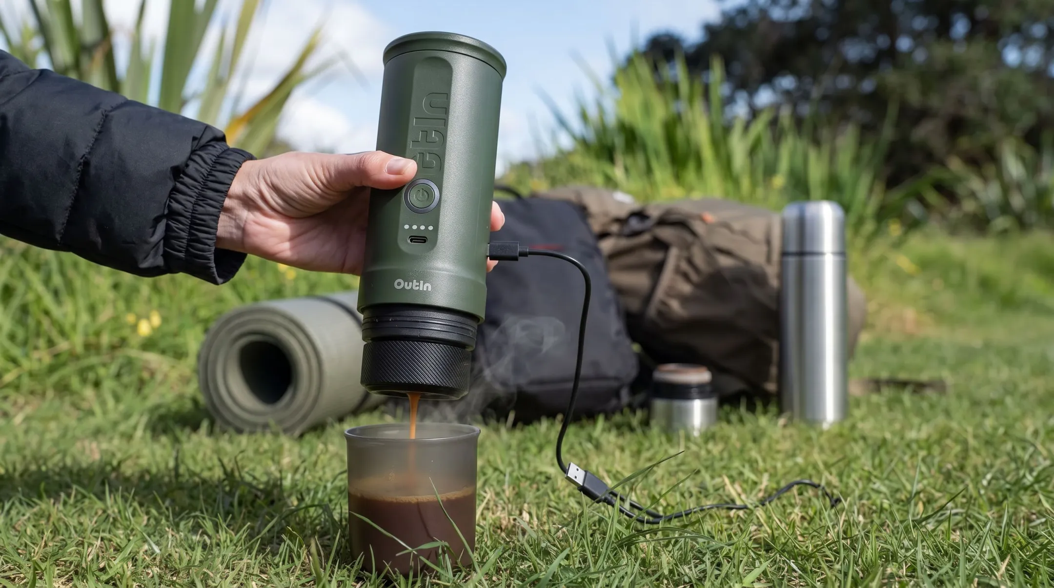 Portable rechargeable espresso machine brewing coffee outdoors