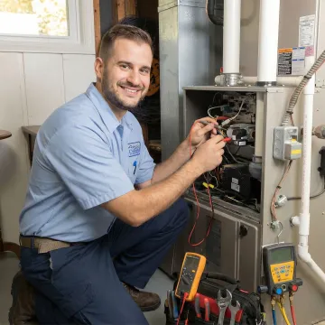 HVAC technician repairing residential furnace in Navasota Texas home