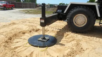 Crane outrigger pad on sandy soil job site showing ground condition assessment