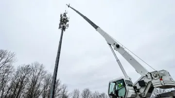 Mobile crane at full boom extension on utility telecom construction site
