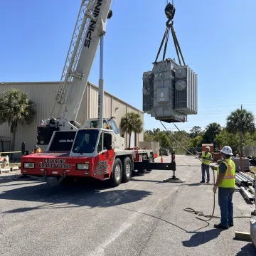 Mobile crane lifting heavy equipment in Florida