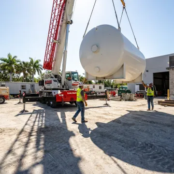 Crane lifting heavy equipment at a Florida job site
