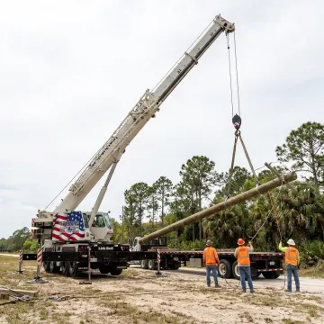 Crane lifting utility pole in Florida