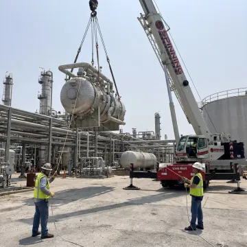 Crane lifting industrial equipment at a petrochemical facility in Florida
