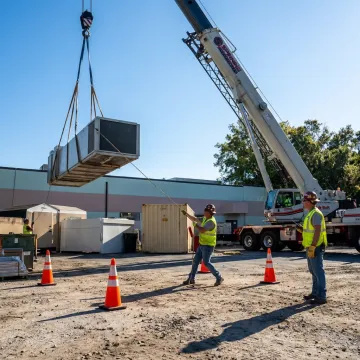Crane lifting heavy equipment at an Ocala job site