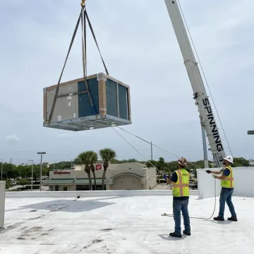 Crane lifting rooftop HVAC equipment in Florida