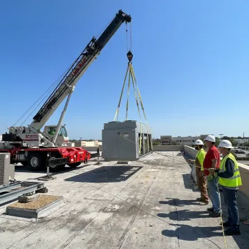 Crane lifting rooftop HVAC equipment in Florida