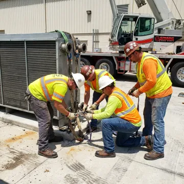Rigging crew securing heavy industrial equipment
