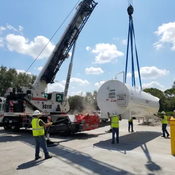 Crane lifting industrial machinery in Florida