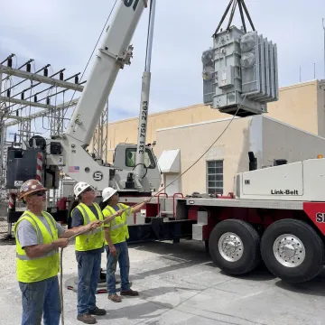 Mobile crane lifting heavy equipment on a Florida job site