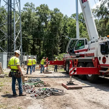 Crane operator preparing telecom rigging equipment
