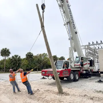Crane lifting utility equipment in Florida