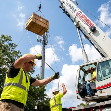 Rigging crew guiding crane lift process