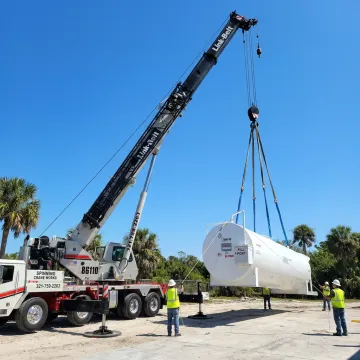 Crane lifting heavy equipment in Florida