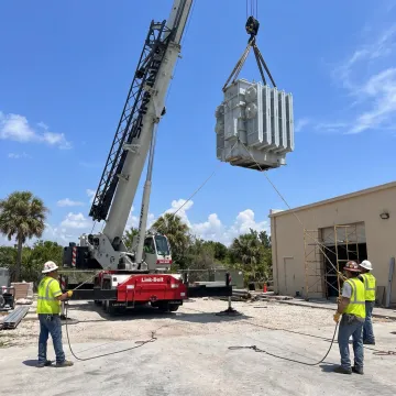 Crane relocating industrial equipment in Florida