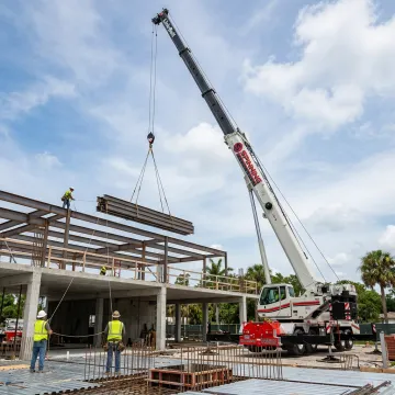 Crane lifting structural steel on a Florida construction site