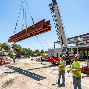 Commercial crane lifting structural steel in Florida