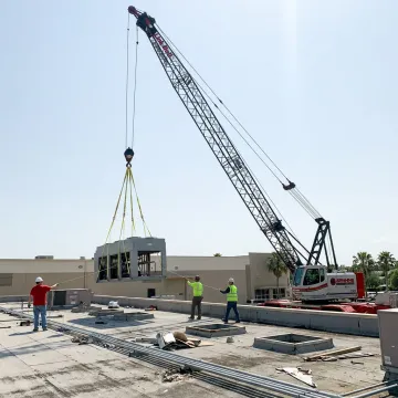 Crane lifting rooftop HVAC equipment in Florida