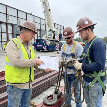 Rigging crew preparing a steel beam lift