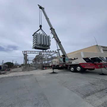 Crane lifting structural steel on a Florida construction site