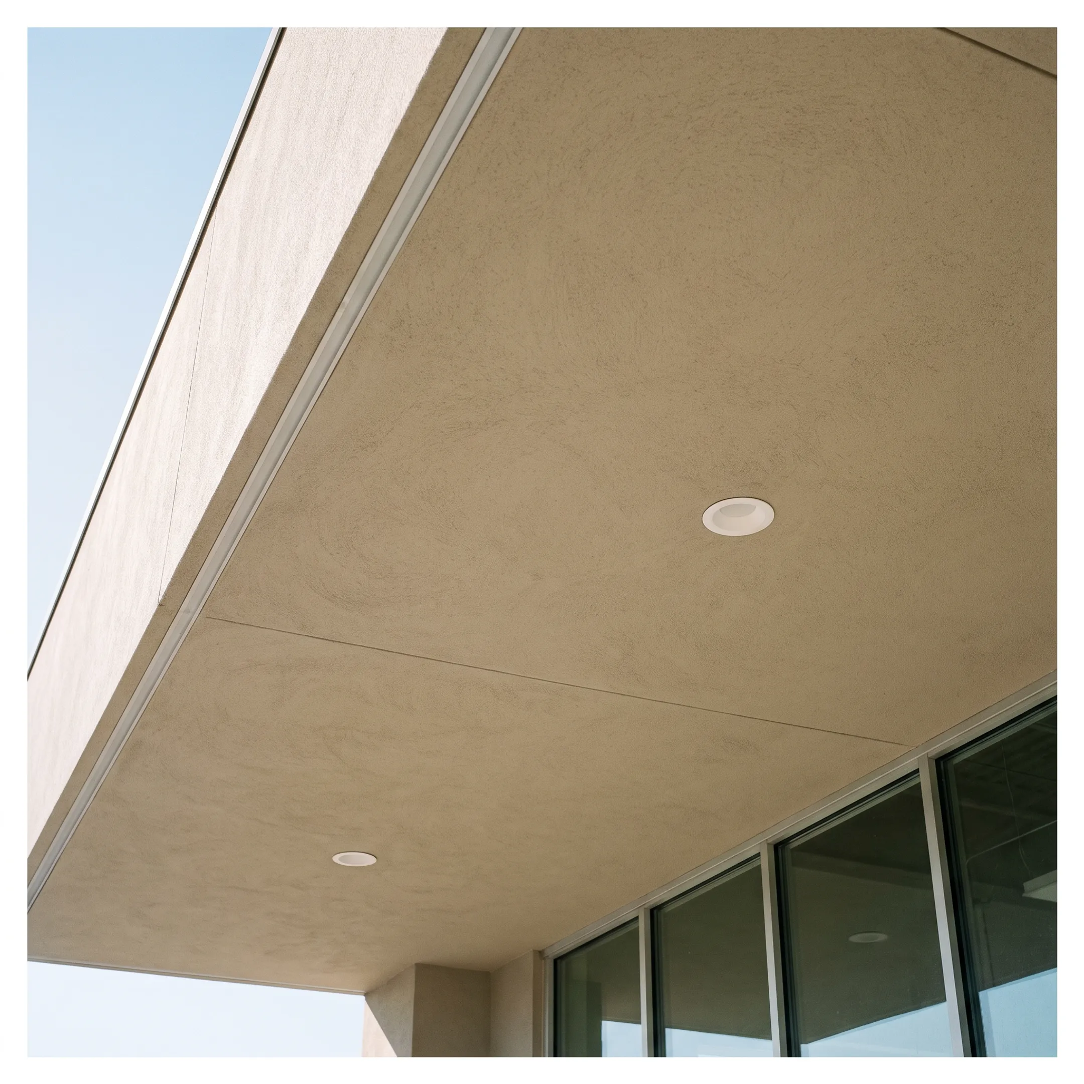 Finished stucco soffit beneath a commercial building overhang