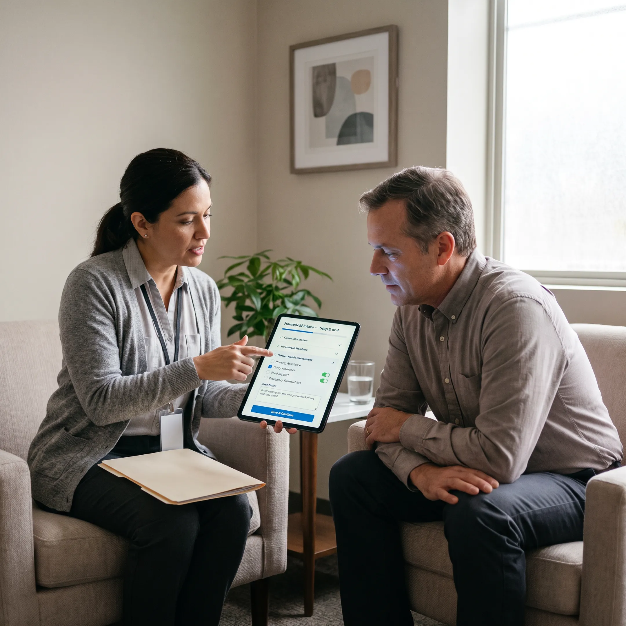 Community health worker assisting a patient with digital intake on a tablet