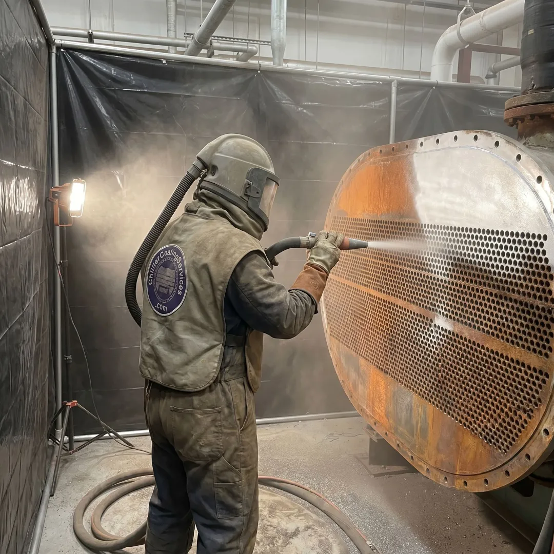 Technician preparing industrial equipment for coating